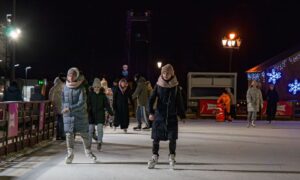 People enjoy ice skating on a well-lit outdoor rink at night. - Photo by Radik 2707 on Pexels